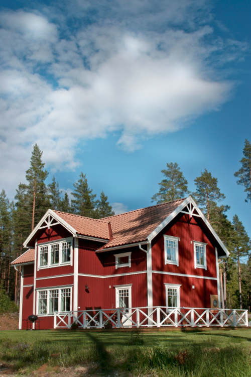 Kauniin punavalkoiseksi maalattu mökkirakennus.